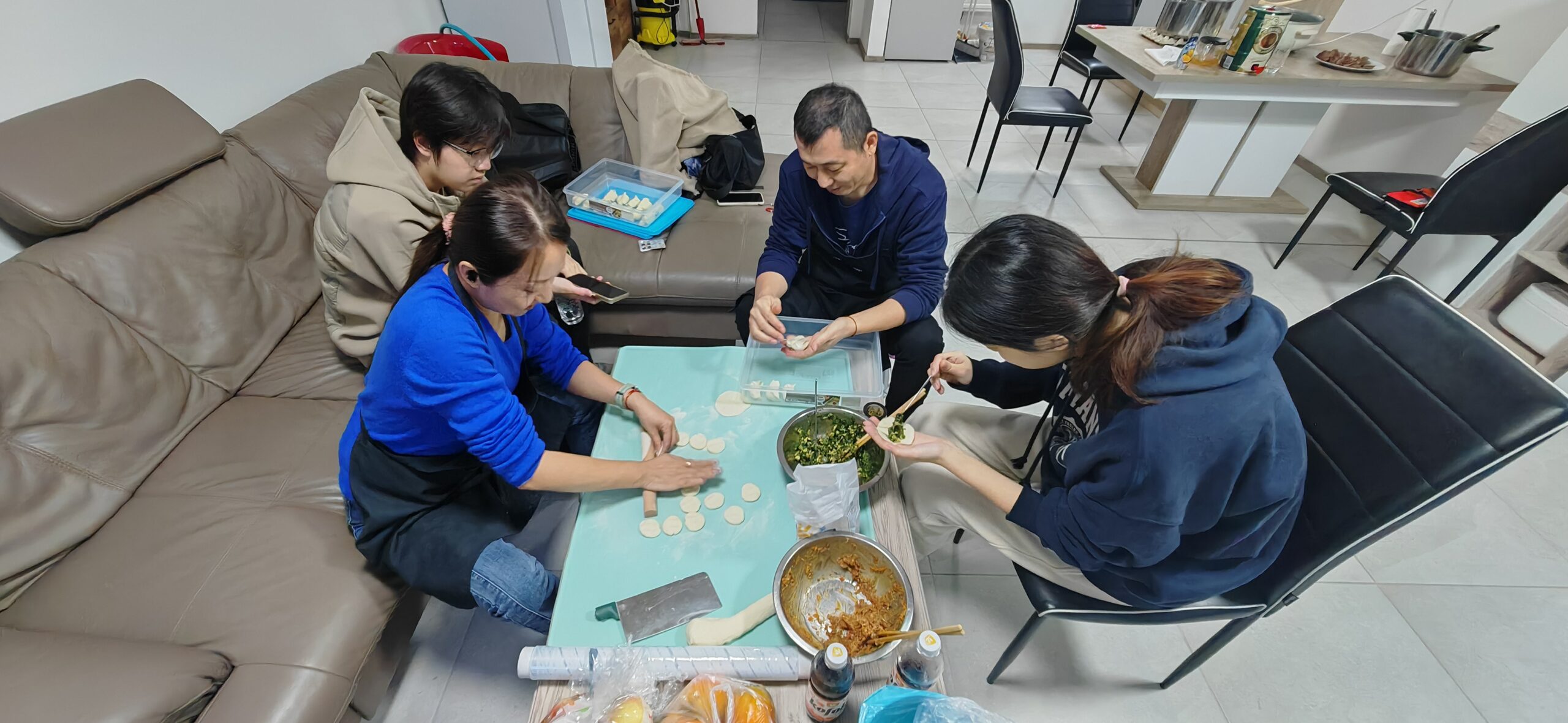 Friends or family preparing dumplings together around a table